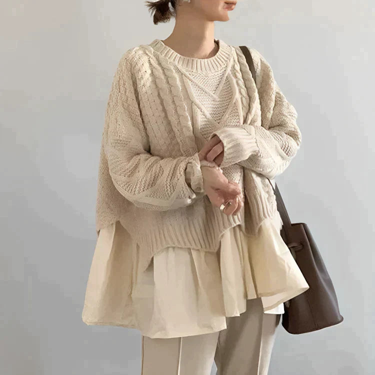 Eine Frau, die in einem beige Gestricktem Pullover posiert