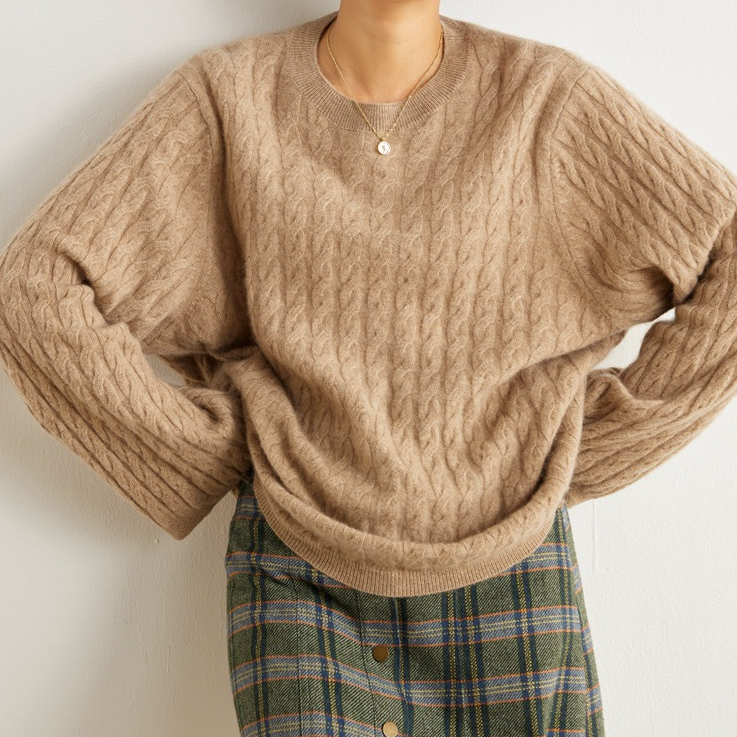 Eine Frau, die einen Beige Strickpullover tragt